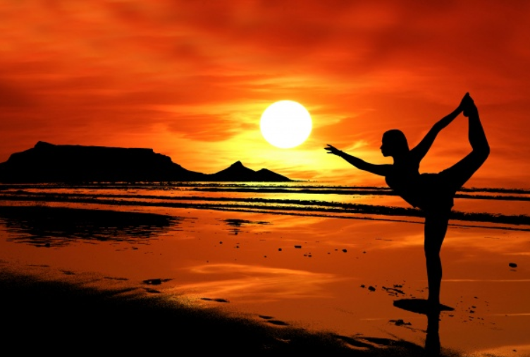 Silhouette of a woman doing yoga at sunset